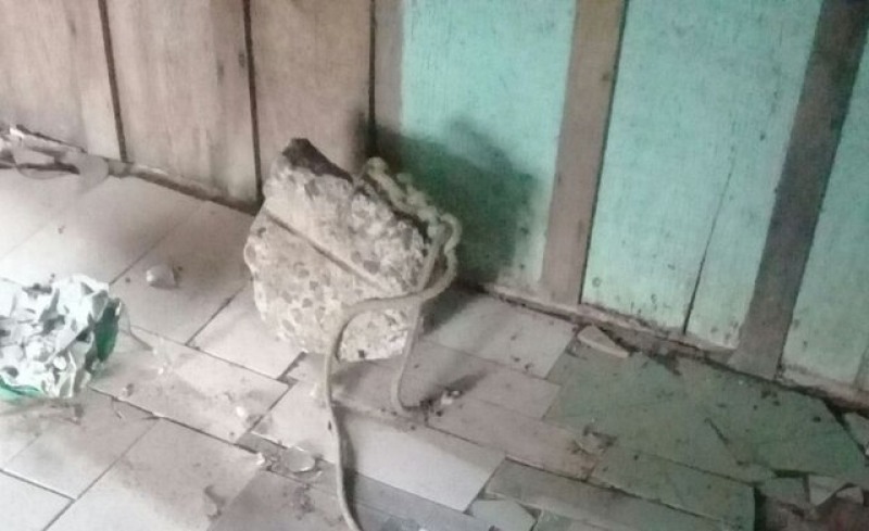 Pedra com uma corda amarrada nela foi encontrada no interior da casa (Foto: Assessoria PM)